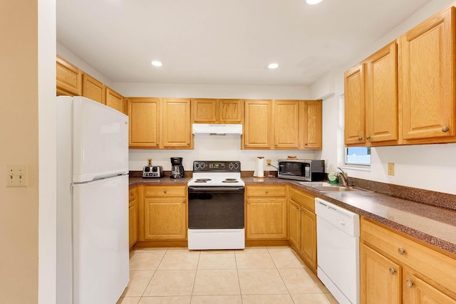 kitchen with dark countertops, white appliances, a sink, and under cabinet range hood