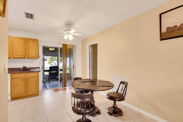 dining room with light tile patterned floors, ceiling fan, visible vents, and baseboards