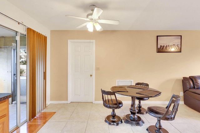 dining area featuring light tile patterned flooring, ceiling fan, and baseboards