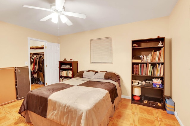 bedroom featuring a ceiling fan, a closet, a spacious closet, and baseboards