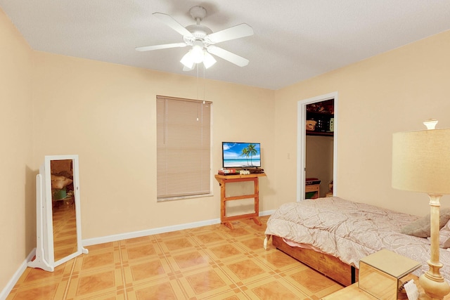 bedroom with a ceiling fan, a closet, a spacious closet, and baseboards