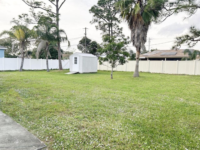 view of yard with a storage shed, a fenced backyard, and an outdoor structure