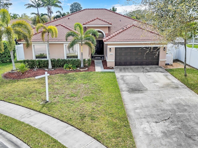 mediterranean / spanish-style home featuring a garage, concrete driveway, a front lawn, and stucco siding