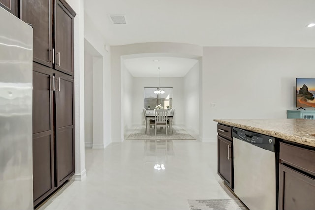 kitchen with arched walkways, dark brown cabinetry, stainless steel appliances, visible vents, and baseboards