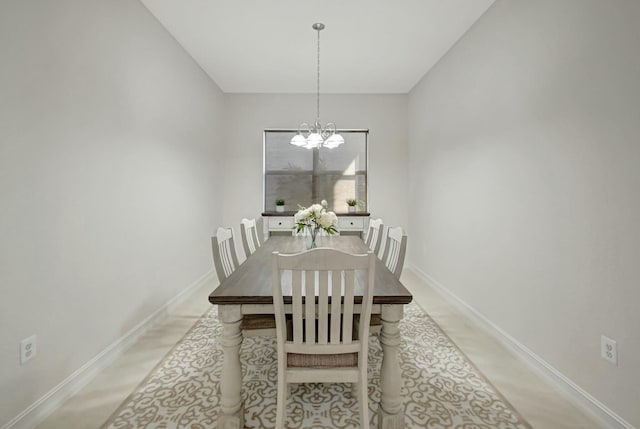 dining area featuring a chandelier and baseboards