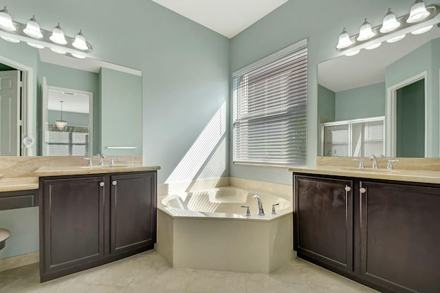 bathroom with a stall shower, two vanities, a sink, and a garden tub