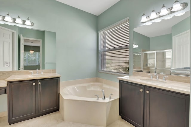 bathroom featuring a stall shower, two vanities, a garden tub, and a sink