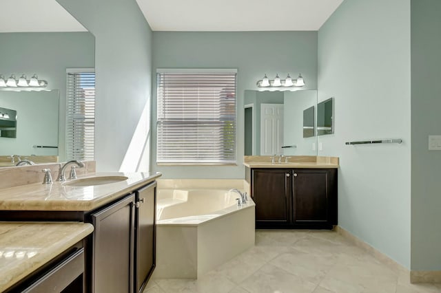 bathroom with a garden tub, two vanities, a sink, and baseboards