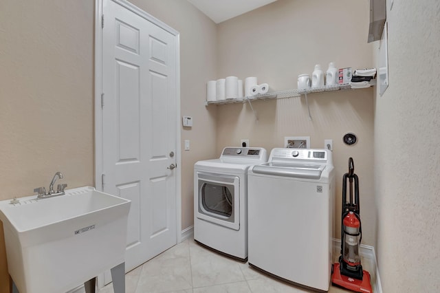 clothes washing area featuring laundry area, separate washer and dryer, and a sink