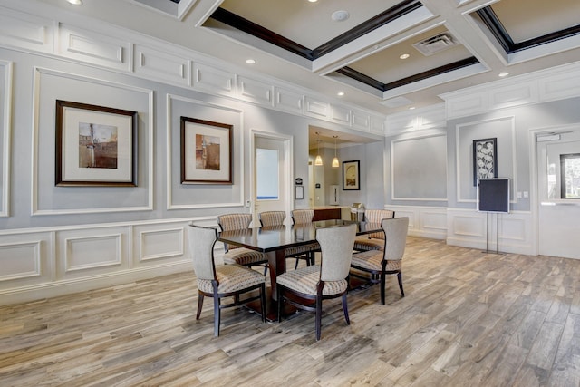 dining room with light wood finished floors, visible vents, a decorative wall, coffered ceiling, and beamed ceiling