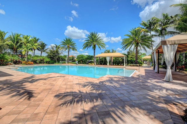 community pool with a gazebo and a patio area