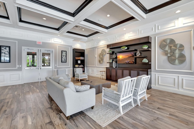 living room featuring french doors, beamed ceiling, and a decorative wall