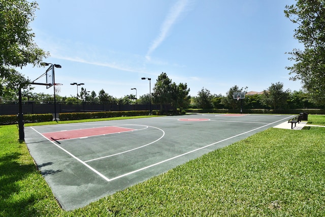 view of basketball court with community basketball court, a lawn, and fence