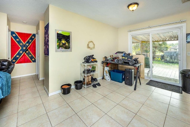 interior space with light tile patterned floors, visible vents, baseboards, and a textured ceiling