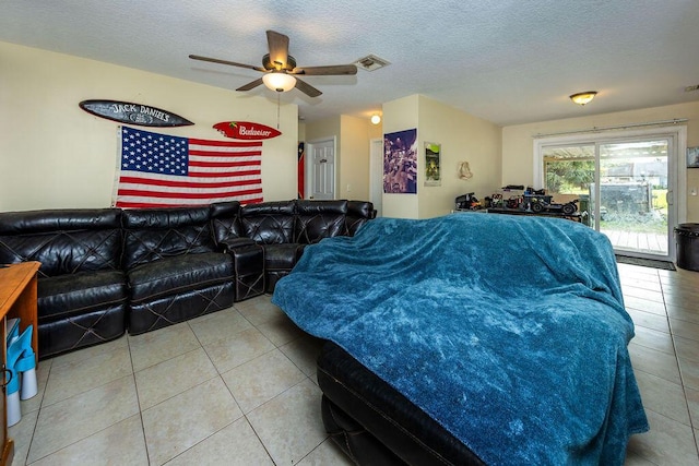 living room featuring a textured ceiling, a ceiling fan, visible vents, and tile patterned floors