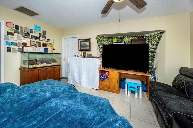 tiled bedroom with a ceiling fan, visible vents, and a textured ceiling