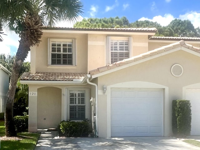 view of front of house featuring a garage, stucco siding, concrete driveway, and a tiled roof