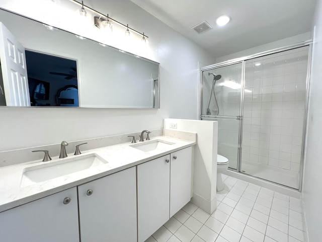 bathroom with toilet, double vanity, a sink, and visible vents