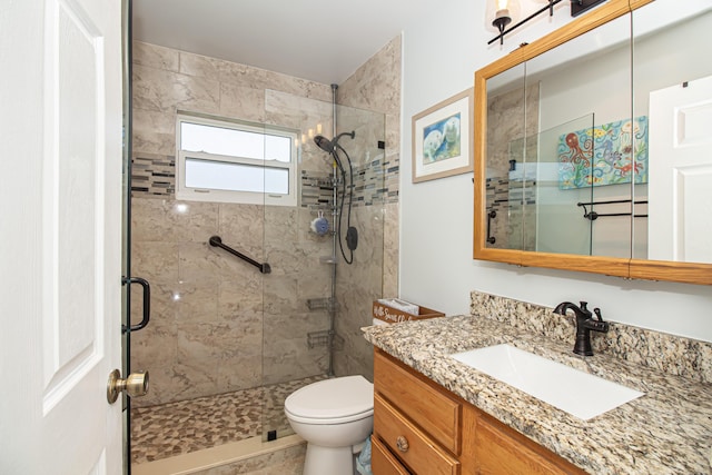 bathroom featuring a stall shower, vanity, and toilet