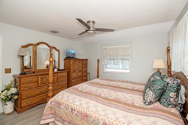 bedroom with light wood-style floors, visible vents, and a ceiling fan