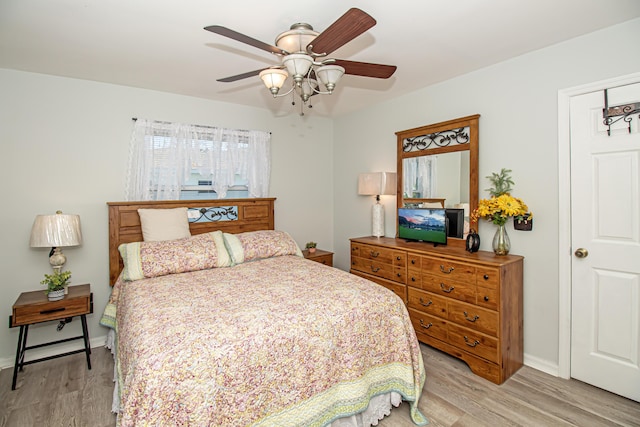 bedroom with ceiling fan, light wood-type flooring, and baseboards