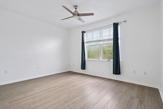 empty room with baseboards, ceiling fan, and light wood finished floors