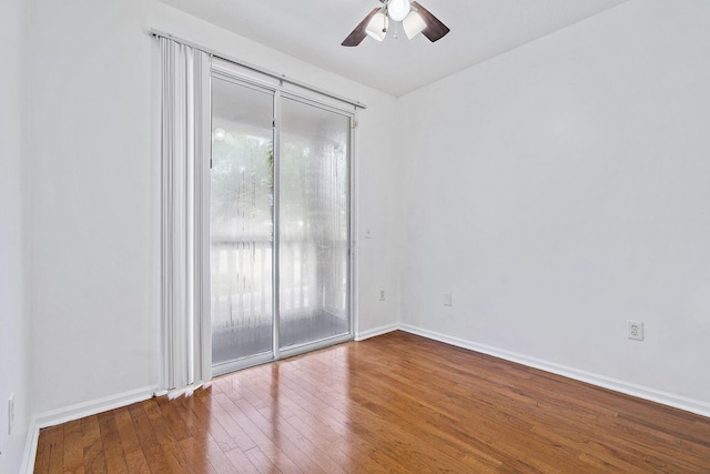 empty room featuring wood finished floors, a ceiling fan, and baseboards