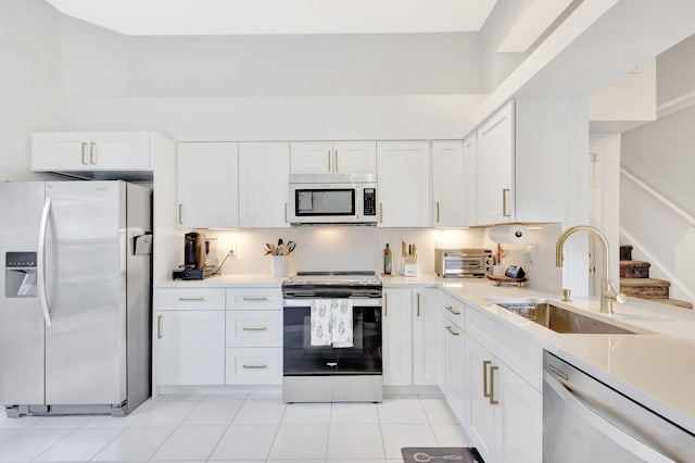 kitchen featuring light countertops, appliances with stainless steel finishes, a sink, and white cabinetry