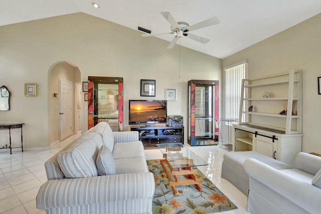 living area with arched walkways, high vaulted ceiling, light tile patterned flooring, a ceiling fan, and baseboards