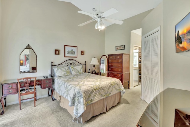 bedroom with a ceiling fan, a closet, light carpet, and high vaulted ceiling