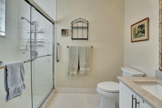 bathroom with tile patterned floors, a shower stall, toilet, and vanity