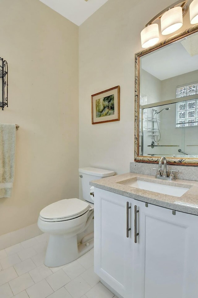 full bathroom featuring toilet, a stall shower, tile patterned flooring, and vanity