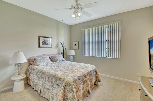 carpeted bedroom featuring baseboards and a ceiling fan