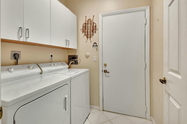 laundry room featuring cabinet space, light tile patterned floors, baseboards, and washer and dryer