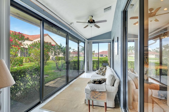 sunroom with lofted ceiling, ceiling fan, and visible vents