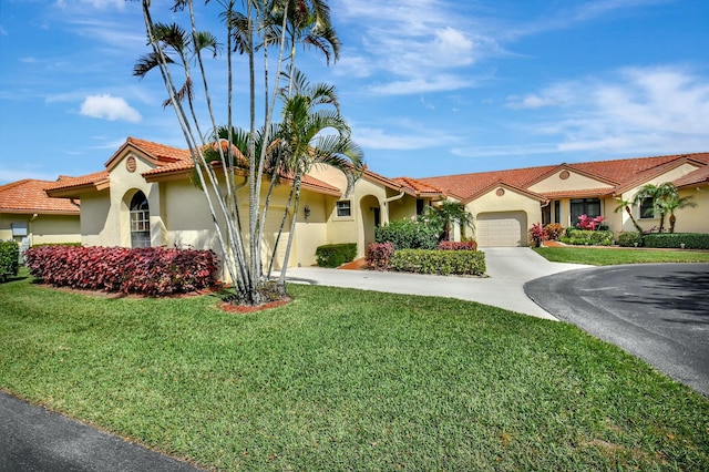 mediterranean / spanish house with a tile roof, stucco siding, concrete driveway, a garage, and a front lawn