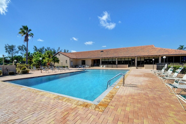 pool with a patio and fence