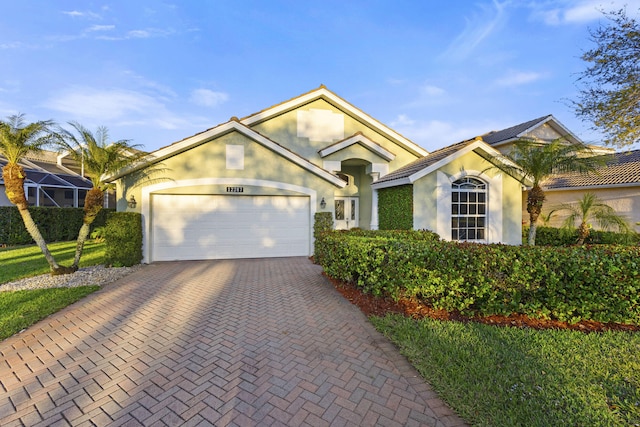 view of front of house featuring stucco siding, decorative driveway, and a garage