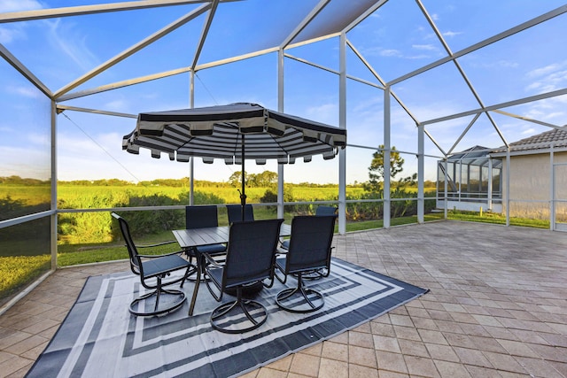 view of patio with outdoor dining space and glass enclosure