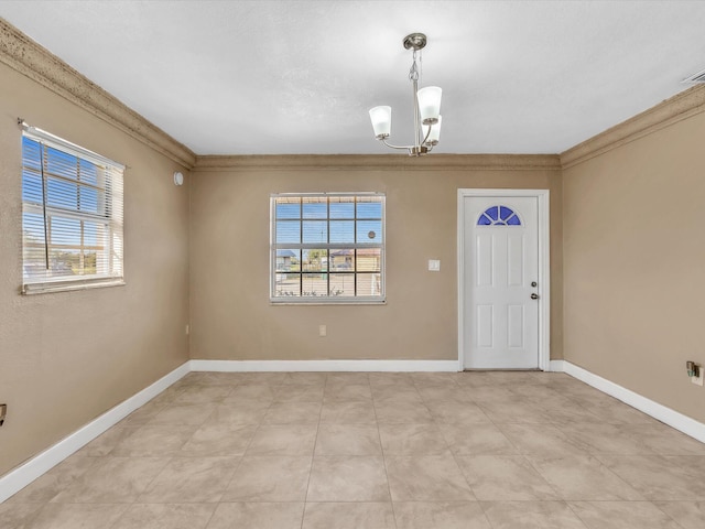 foyer entrance with baseboards, a notable chandelier, and crown molding