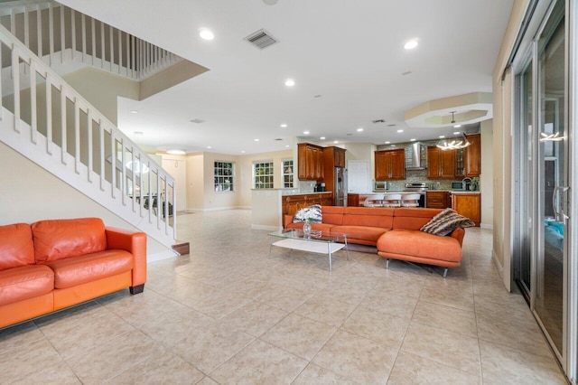 living area featuring recessed lighting, visible vents, baseboards, stairway, and light tile patterned flooring