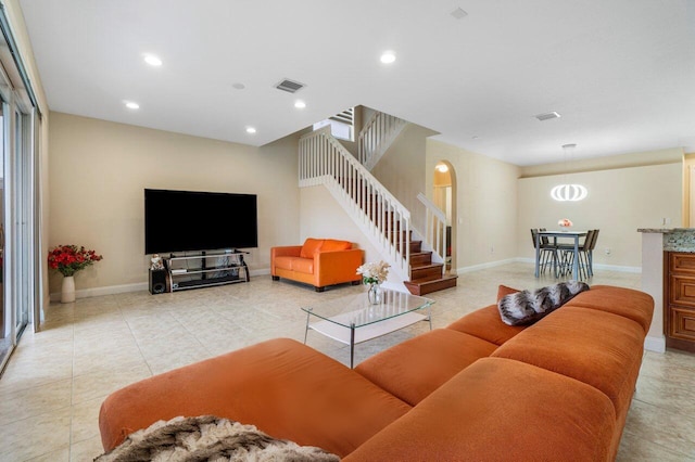 living room featuring light tile patterned floors, baseboards, stairway, and recessed lighting