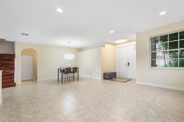 interior space with arched walkways, recessed lighting, visible vents, and baseboards