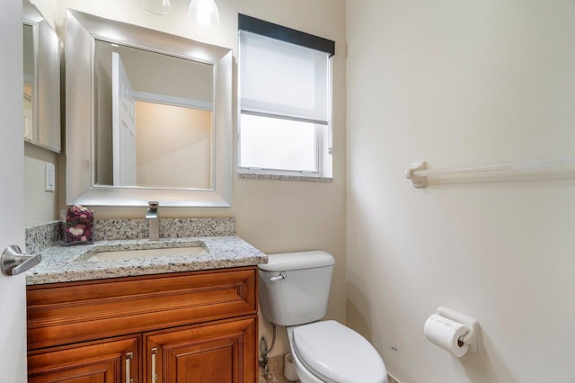 half bathroom with toilet and vanity