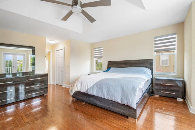 bedroom featuring hardwood / wood-style flooring, multiple windows, and baseboards