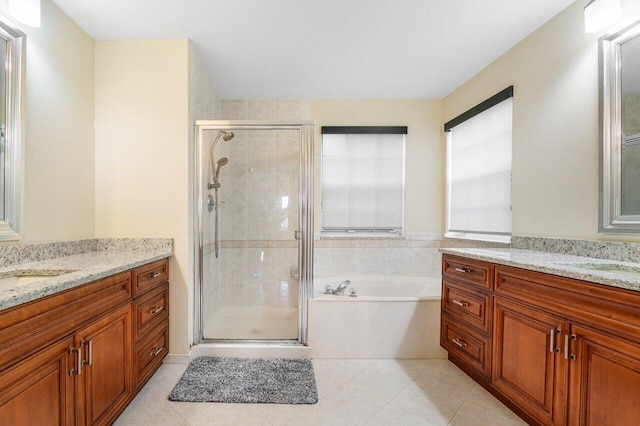 full bath with a stall shower, two vanities, a sink, and tile patterned floors