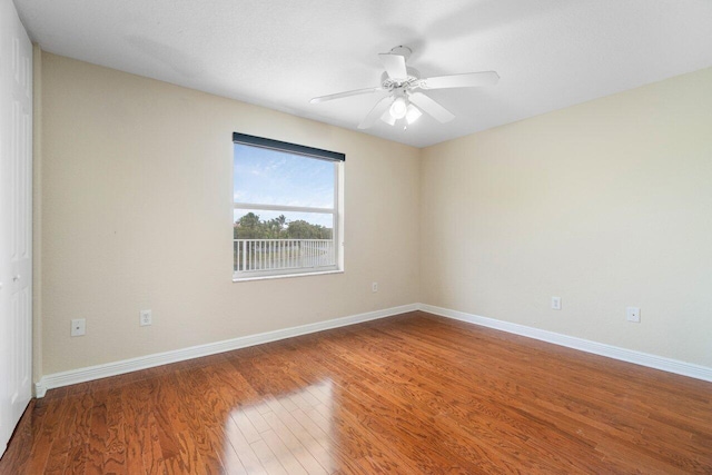 unfurnished room featuring ceiling fan, baseboards, and wood finished floors