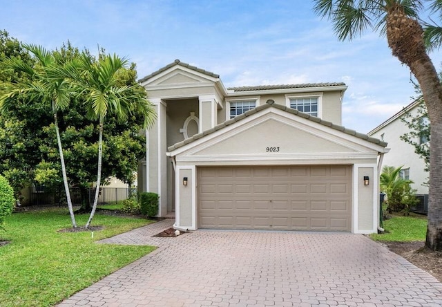 view of front of property with decorative driveway, a front lawn, and stucco siding