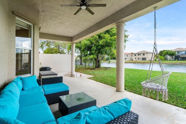 view of patio featuring ceiling fan, a water view, fence, and an outdoor hangout area