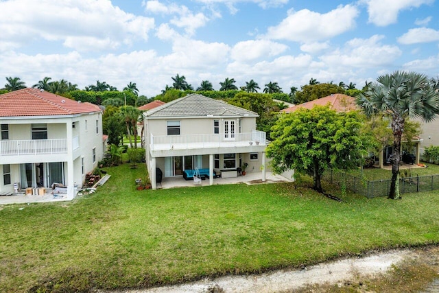 back of house with a balcony, a patio area, fence, and a yard